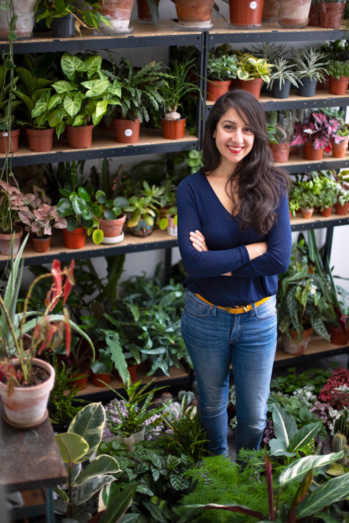 Sabrina brume la boutique devant une étagère de plantes